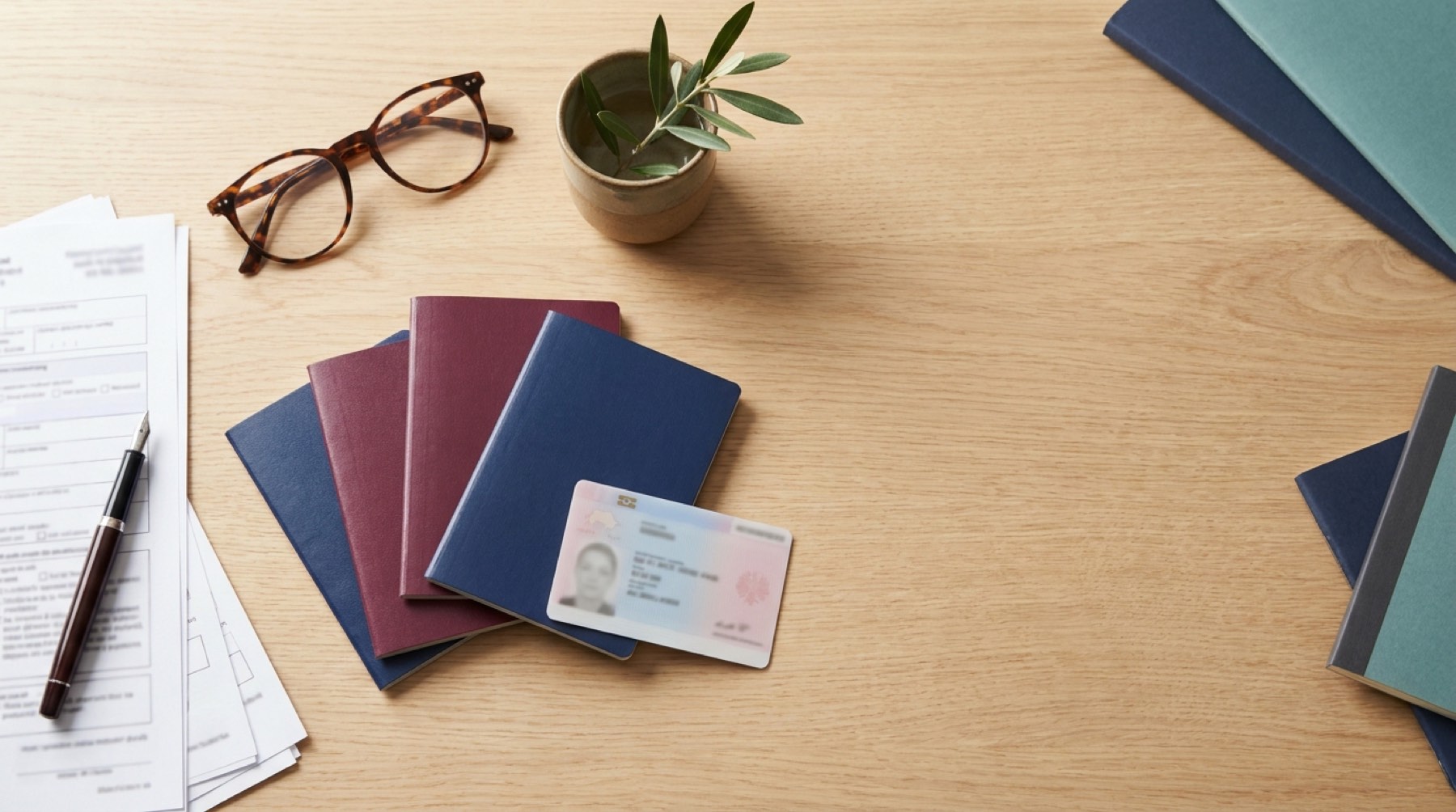 Pasaportes, tarjeta de residencia TIE y formularios de extranjería sobre una mesa de despacho
